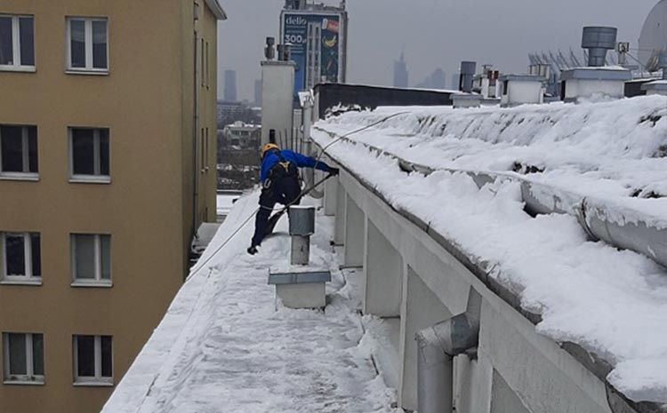 Odśnieżanie dachu w kamienicy